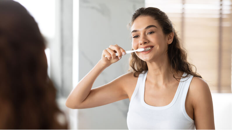 young lady brushing her teeth