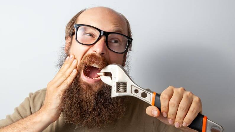 man pulling his own tooth