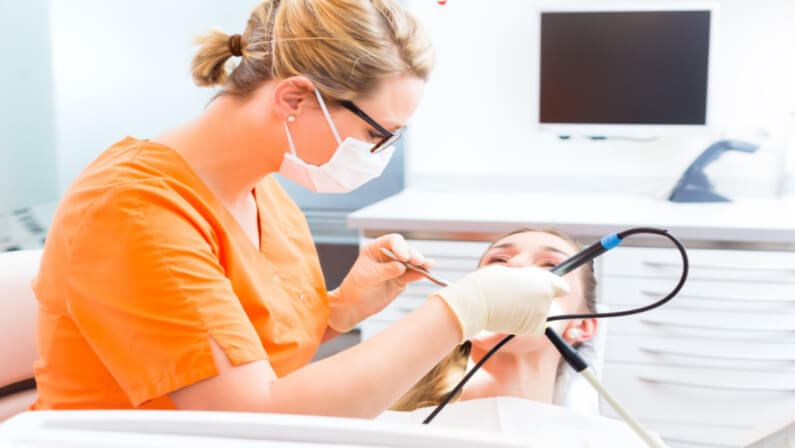 dentist doing deep cleaning on patients teeth