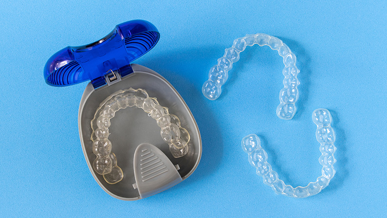 Invisalign braces or invisible retainer on blue background