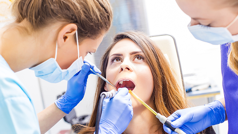 Beautiful woman patient having dental treatment at dentist's office.