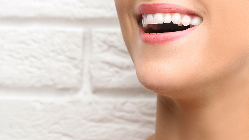 Young beautiful woman with healthy teeth smiling on light background