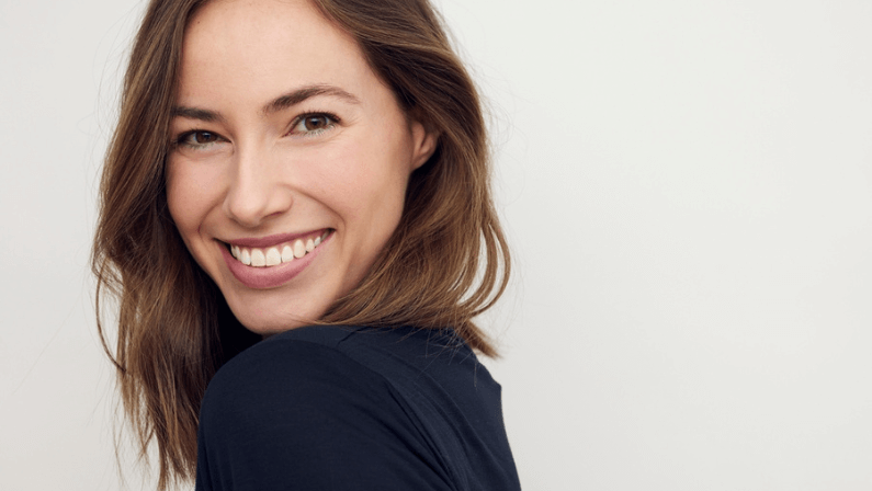 Beautiful portrait of young happy woman with a big smile on her face. Looking cute and sexy in camera, standing isolated on white background with copyspace.
